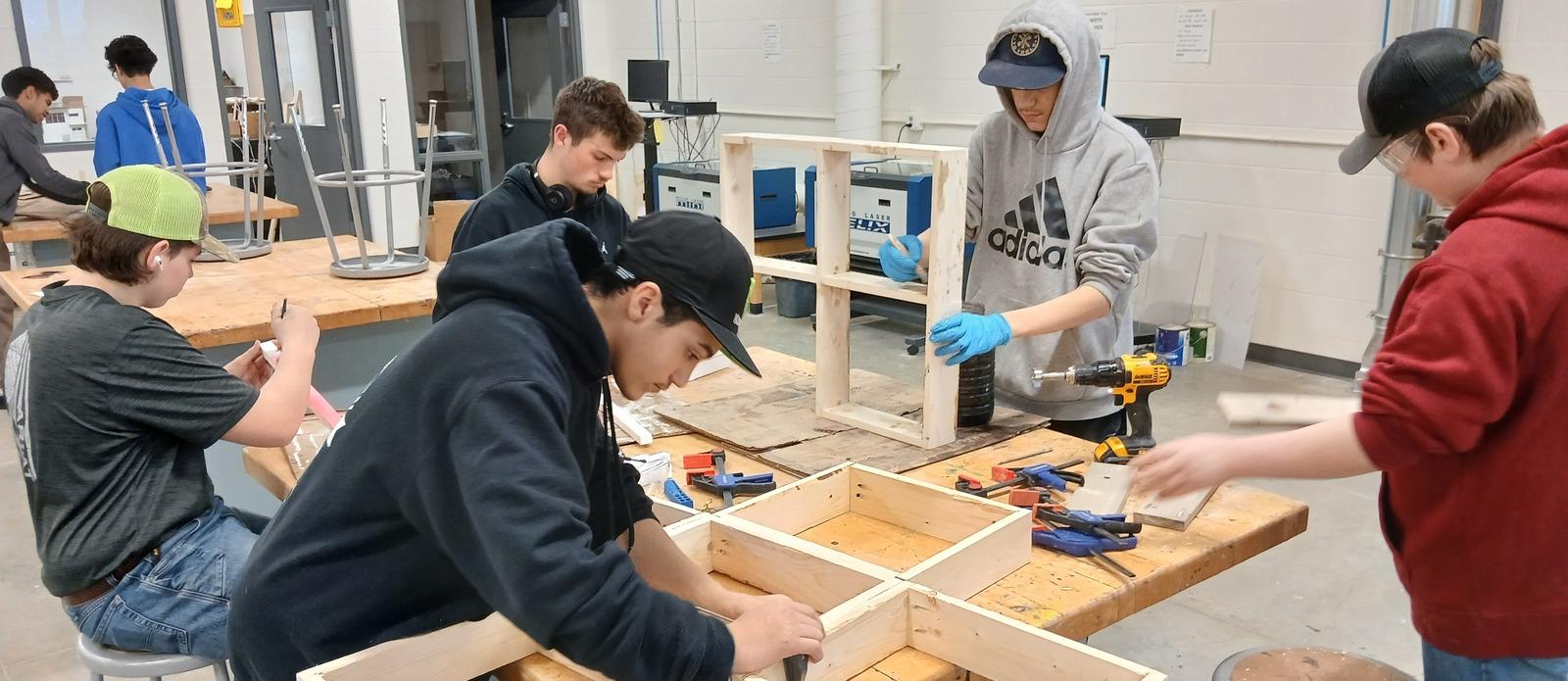 High school students building wood frames in a shop class